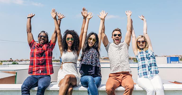 Happy group of friends with arms up