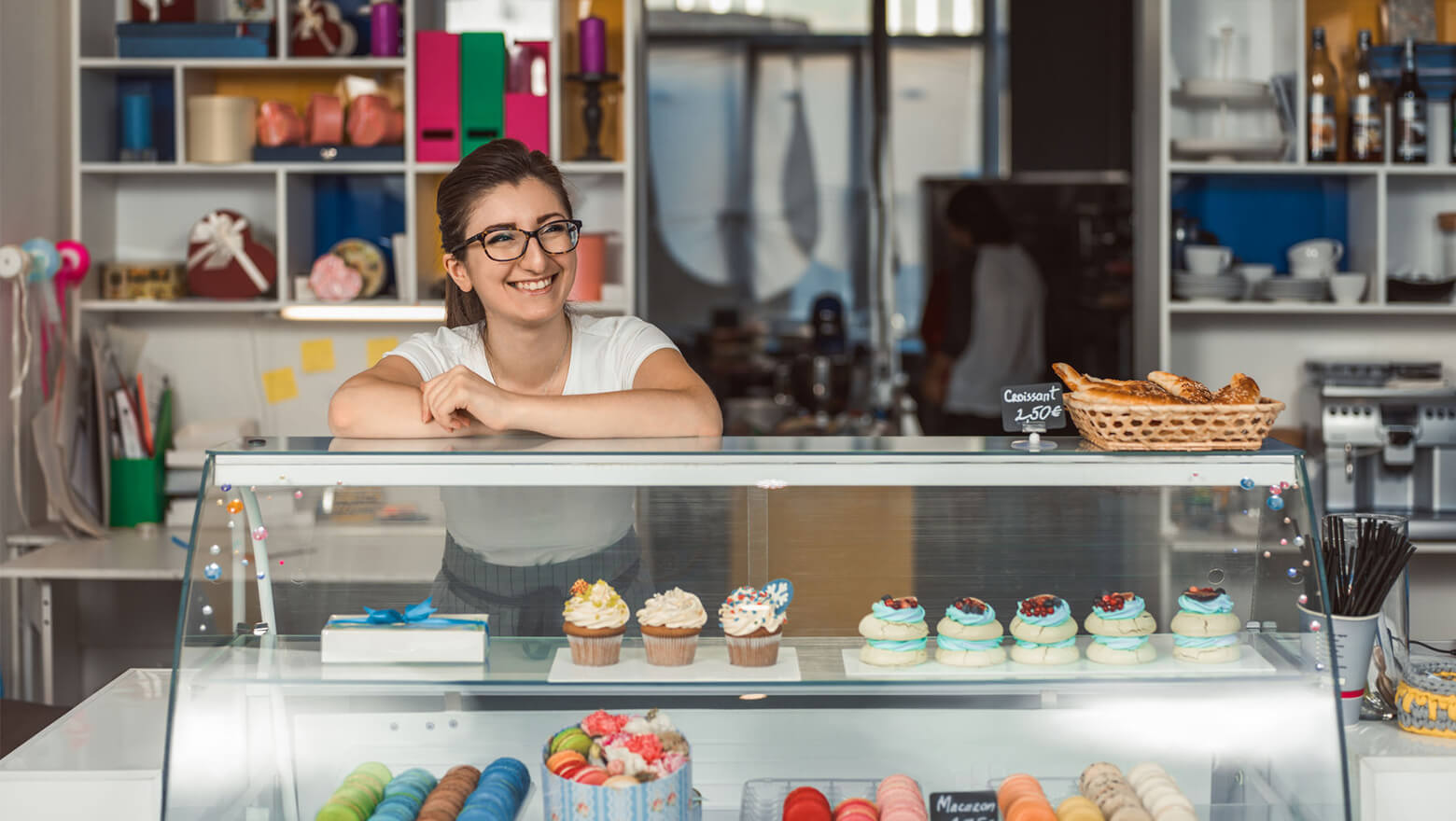 woman behind counter at a cupcake shop