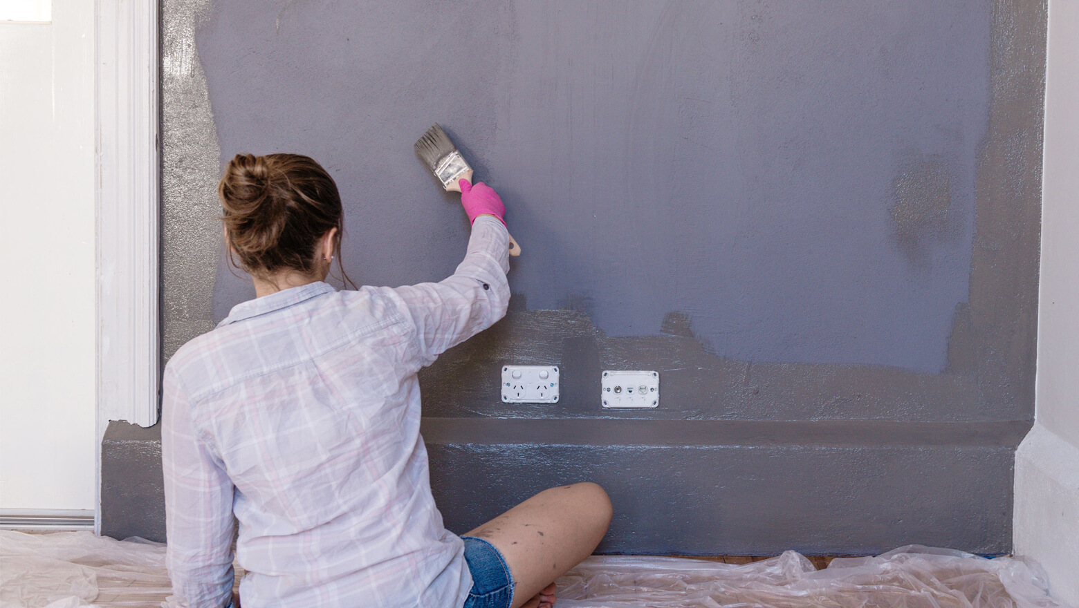 Woman painting a wall