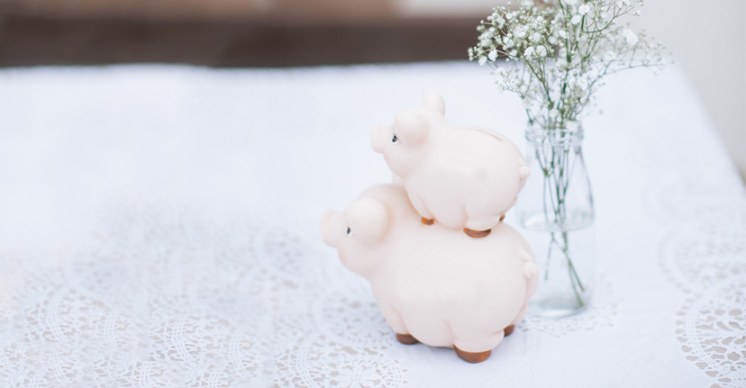 Stacked piggy banks on white tablecloth