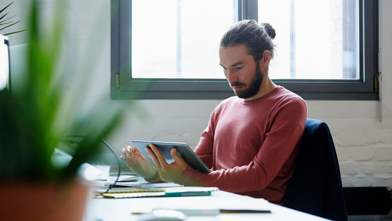 Man at desk on tablet