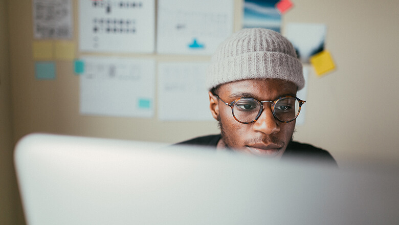 man with beanie on computer