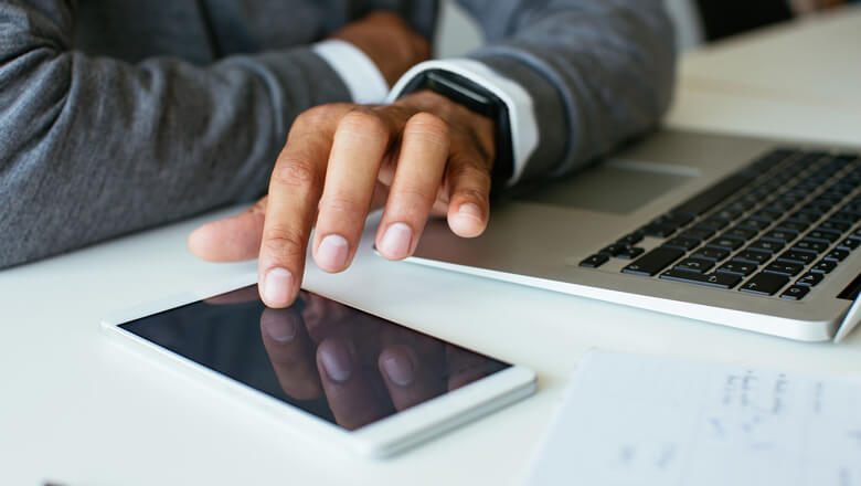 man with computer and phone