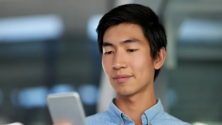 A man looking up dollar-cost averaging for crypto on his phone.