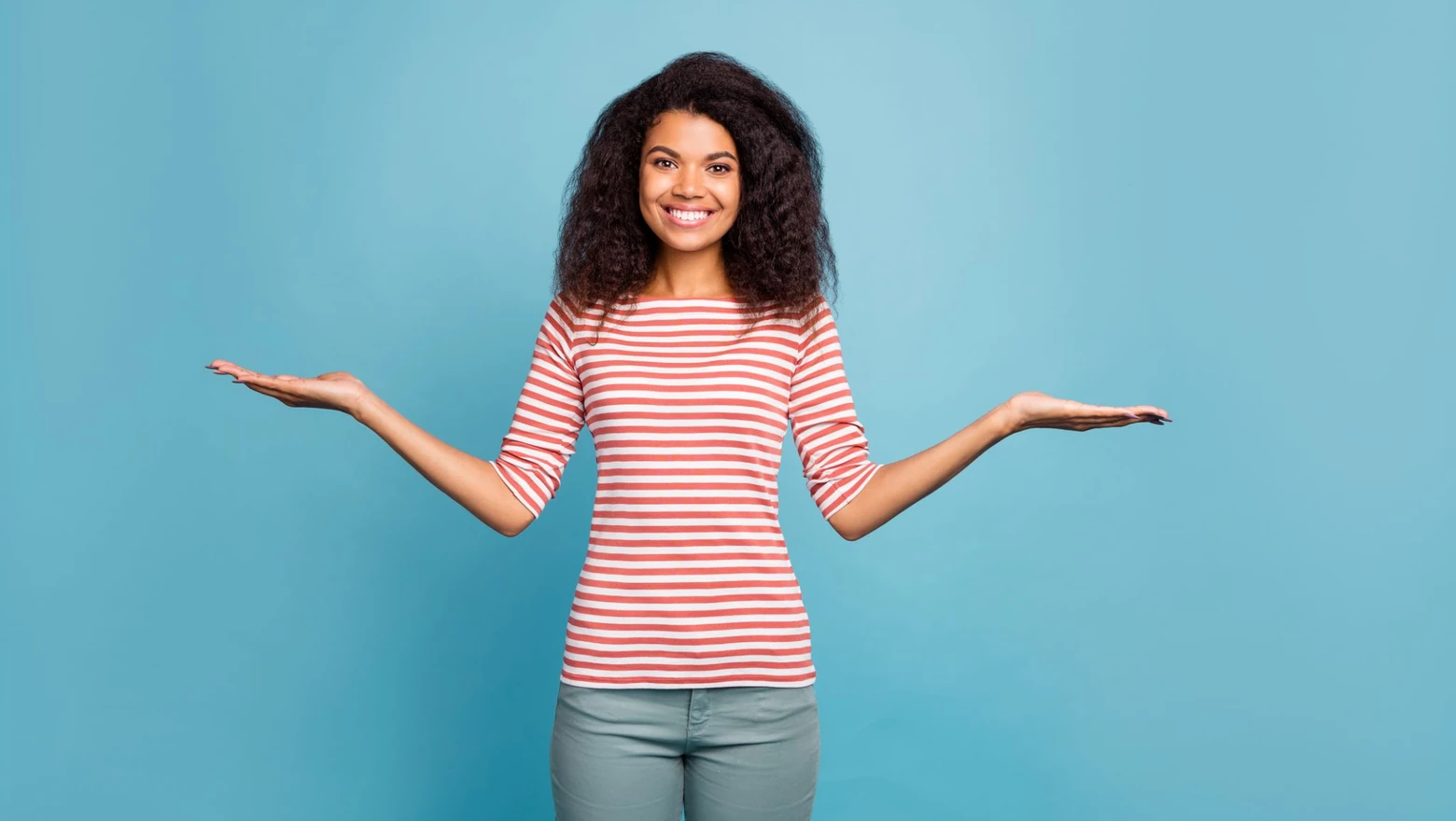 A woman in front of a blue background holding up her hands as if presenting two options.