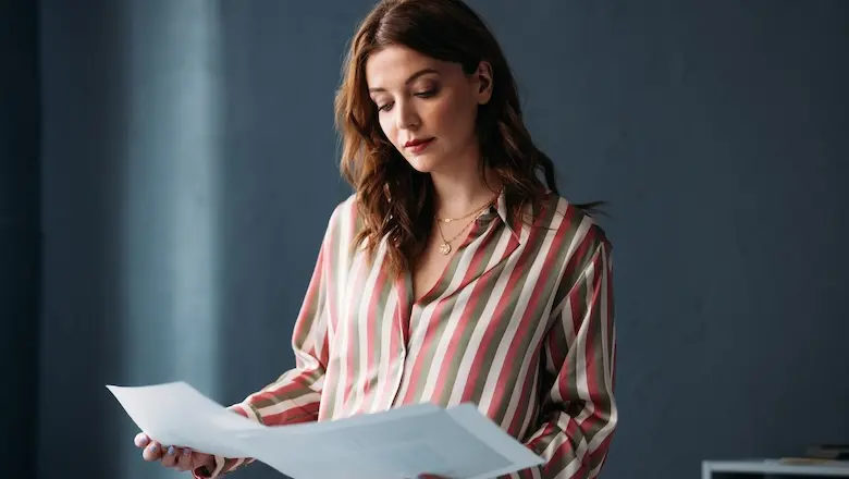 A woman looking at papers listing membership rewards.