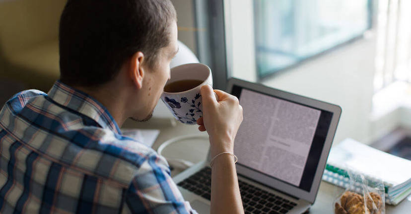 man with coffee at desk