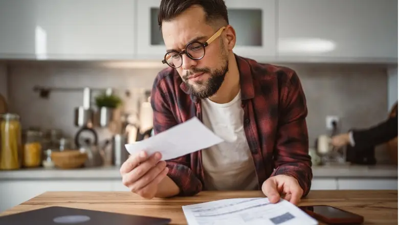 Man reading a document at his kitchen table.