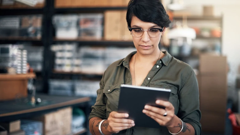 A small business owner researching merchant accounts on a tablet.
