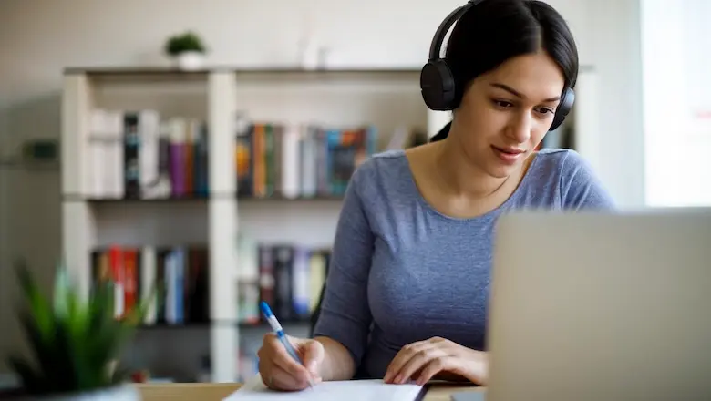 A woman researches what the most profitable businesses are on a computer at a desk.