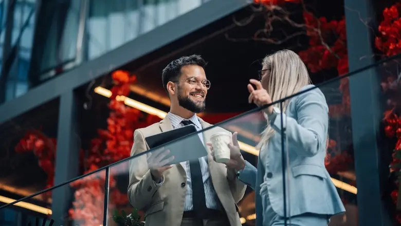 Two people discuss how to advertise a business outside of a building.