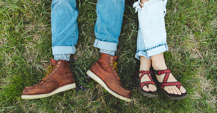 Couples' feet laying in grass