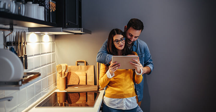 couple in kitchen on tablet