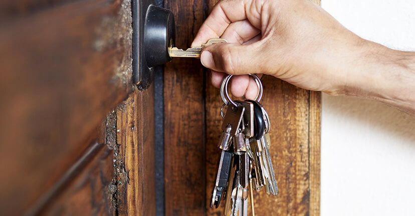 hand turning key in door