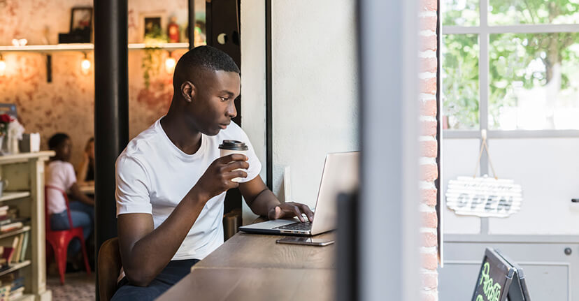 man drinking coffee with laptop