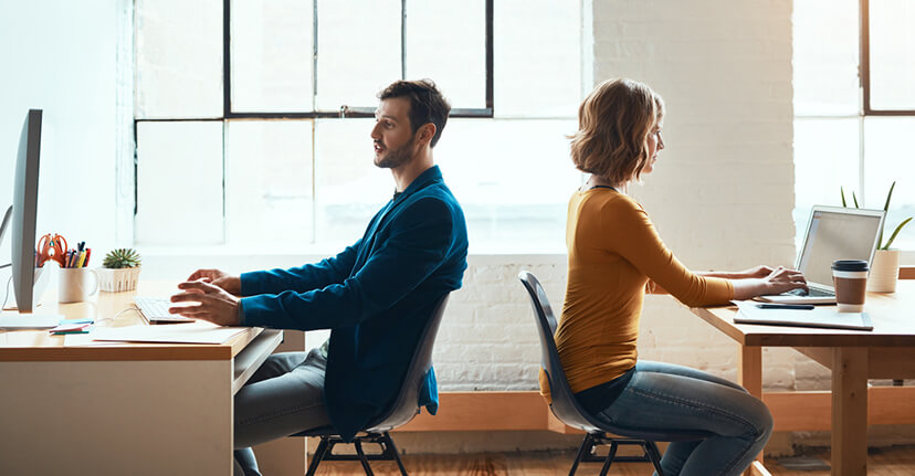 Man and woman in office back to back