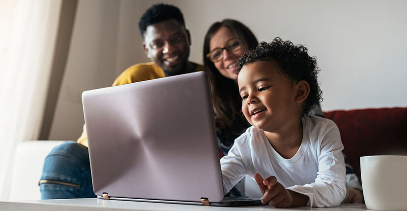 parents with child on laptop