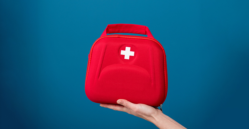 Red first aid kit on blue background