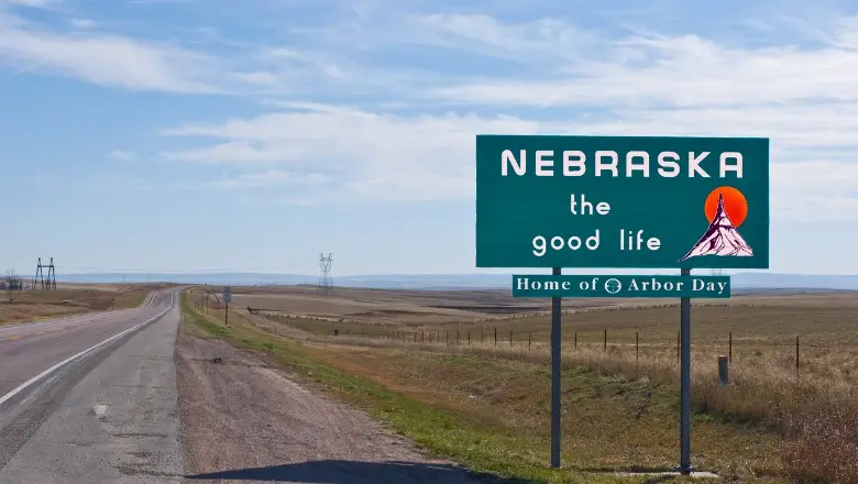 A green roadside sign welcomes travelers to Nebraska, 