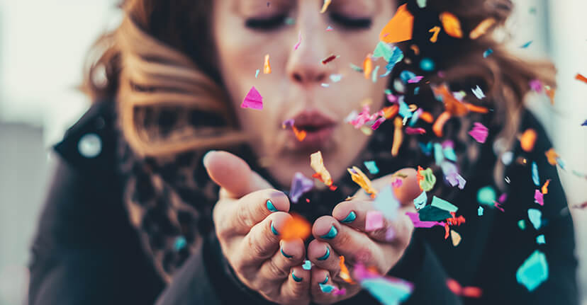 woman blowing confetti